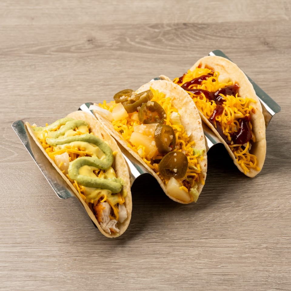 Three Island Taco Shack tacos with diverse toppings, including avocado crema, pineapple, and BBQ sauce.