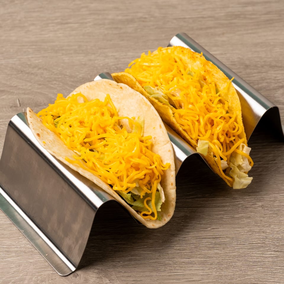 Two Island Taco Shack tacos, one hard shell and one soft shell, filled with cheese and lettuce.